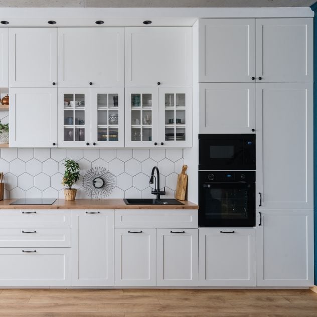 A kitchen with white cabinets and blue walls