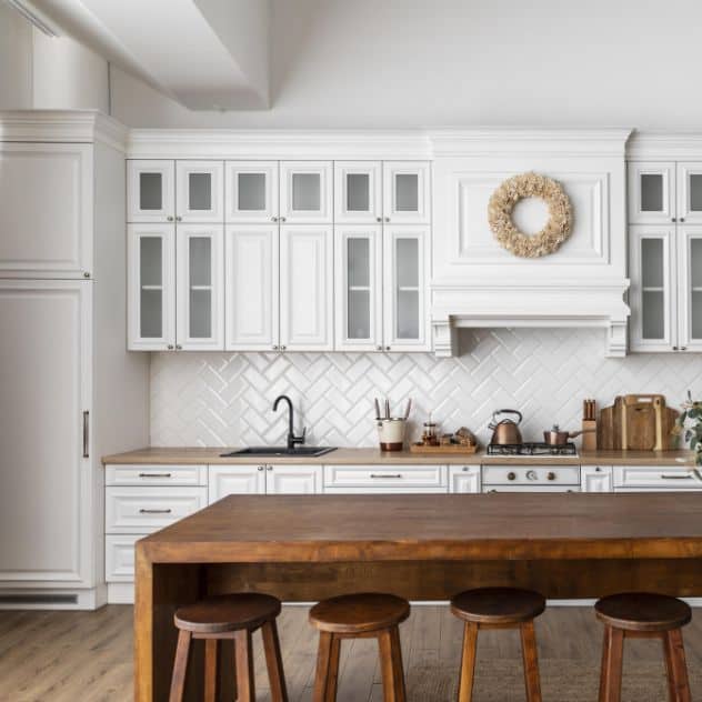 A kitchen with white cabinets and wooden countertops