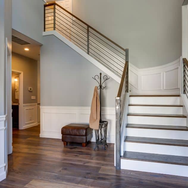 A welcoming foyer with a staircase and a cozy bench